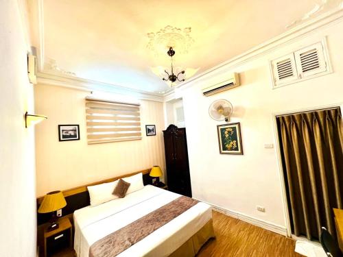 a bedroom with a bed and a chandelier at Hanoi Win Hotel & Travel in Hanoi