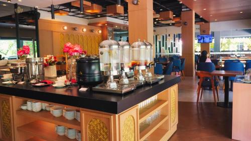 a restaurant with a counter top with food and drinks at OPI Indah Hotel in Palembang