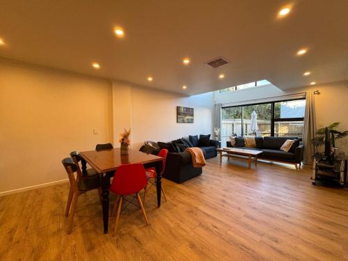 a living room with a table and a couch at NO PARTY ALLOWED, Entire Brand New 3 bedroom townhouse, free unlimited fibre wifi and free parking in Wellington