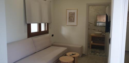 a living room with a white couch and a bathroom at SKIATHOS MODERNO in Skiathos