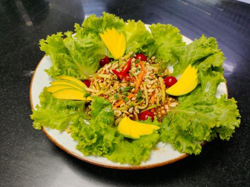 a plate of salad on a table with lettuce at Nambiar Club Bellezea in Bengaluru