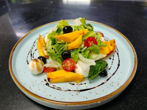 a plate of food with a salad on a table at Nambiar Club Bellezea in Bengaluru