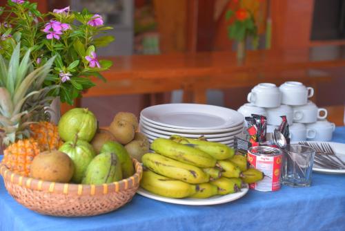 Una mesa azul con plátanos y otras frutas encima. en Duong Thuong - Eco House, en Làng Cac