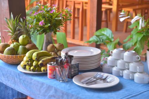 una mesa azul con platos y fruta. en Duong Thuong - Eco House, en Làng Cac