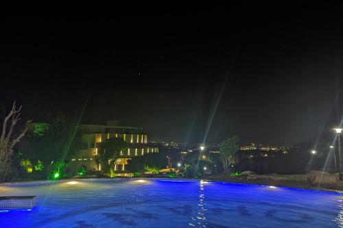 a swimming pool at night with a building in the background at Ohana Village in Phương Phi