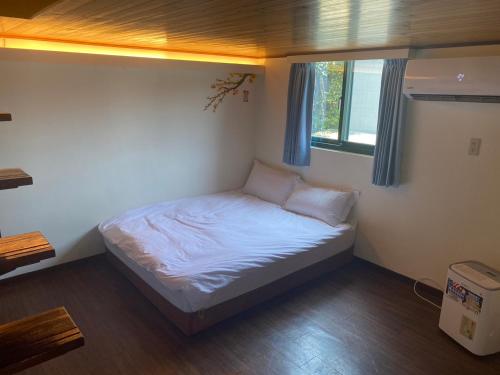 a small bed in a room with a window at Old Street Seaview Homestay in Jiufen
