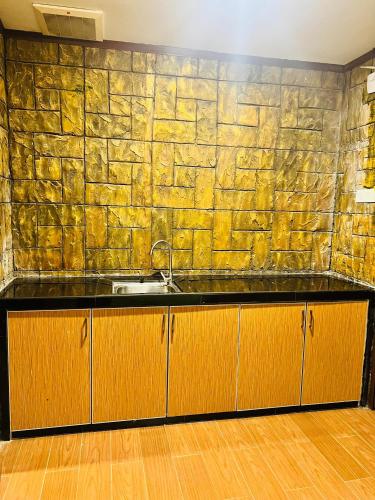 a kitchen with a stone wall and a sink at K Garden Hotel Sungai Petani in Sungai Petani
