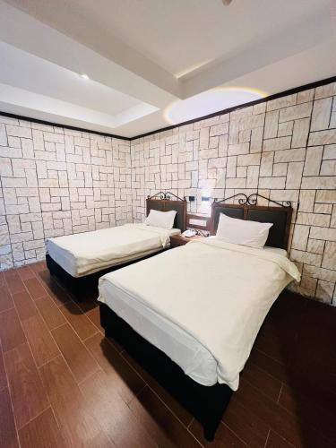 two beds in a room with a wall at K Garden Hotel Sungai Petani in Sungai Petani