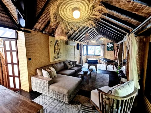 a living room with a couch and a table at Hôtel Fenua Mata'i'oa in Papetoai