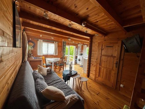 - un salon avec un canapé dans une cabane en rondins dans l'établissement La casa noya sur la route du débarquement d omaha beach, à Le Grand-Hameau