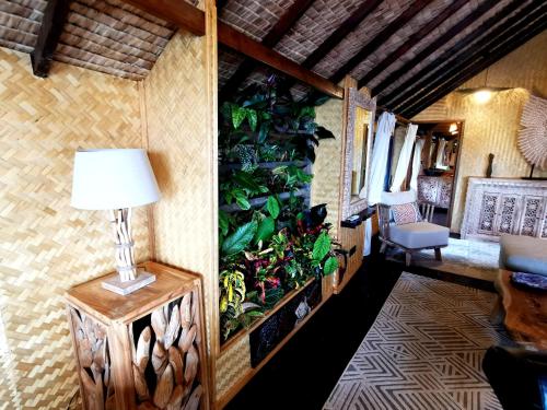 a living room with a plant wall and a lamp at Hôtel Fenua Mata'i'oa in Papetoai