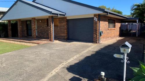a brick house with a garage with a parking meter at Lowset pet friendly home, with room for a boat, Palm Ave, Bongaree in Bellara