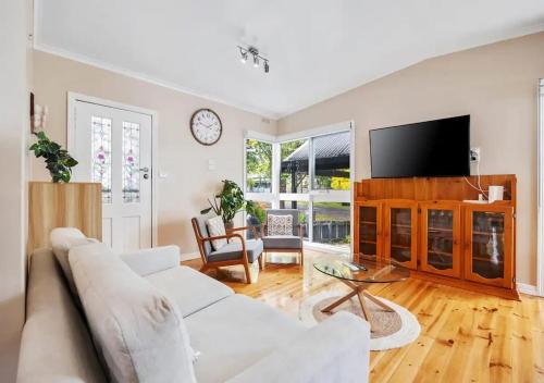 a living room with a white couch and a tv at The Alcove Ballarat in Ballarat