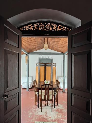a dining room with a table and chairs and an open door at Irene's Home in Matale