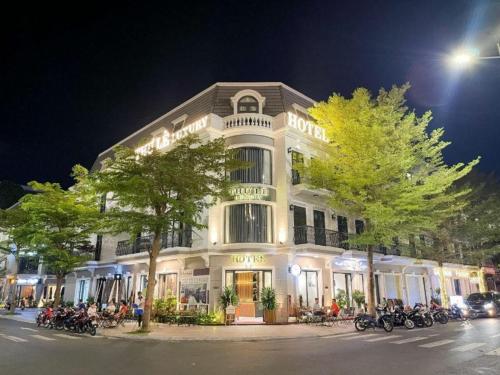 a large white building with motorcycles parked in front of it at KHÁCH SẠN THƯ LÊ LUXURY in Cao Lãnh