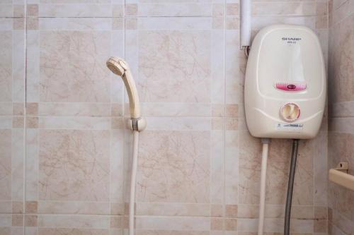a shower in a bathroom with a shower head at Airport View Apartment Cozy room near Airport in Samutprakarn