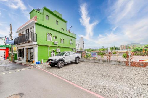 a car parked in front of a green building at 5-1 Homestay in Kenting