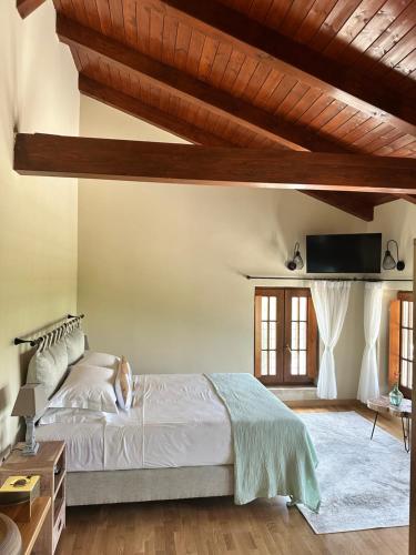 a bedroom with a large bed and a wooden ceiling at Blerina's Agritourism Concept in Laknas