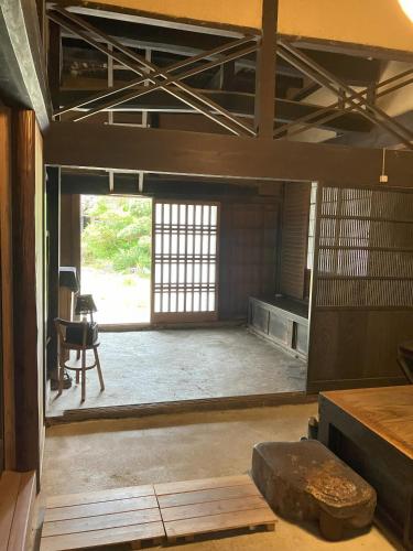 an empty room with a large window in a building at 一日一組限定 古民家の宿 勝右衛門 吉野 in Oyodo