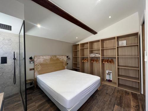 - une chambre avec un grand lit blanc et des étagères dans l'établissement Magnifique vue sur l'esterel, à Saint-Raphaël