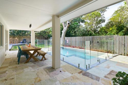 a patio with a table and a swimming pool at Home away from Home at Dicky Beach in Caloundra