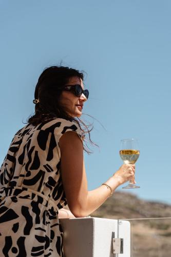 a woman in sunglasses holding a glass of wine at Thalelion 3 bedroom Villas with private pool and Jacuzzi in Naxos Chora