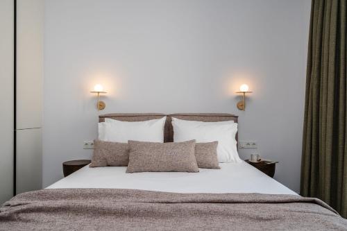 a bedroom with a large white bed with pillows at Thalelion 3 bedroom Villas with private pool and Jacuzzi in Naxos Chora