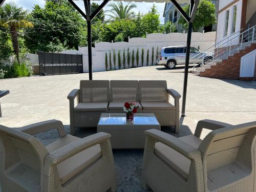 a patio with two chairs and a table with flowers at Batumi Aparthotel 22D in Batumi
