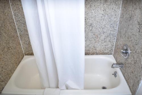 a shower with a white shower curtain in a bathroom at Arlington inn in Arlington