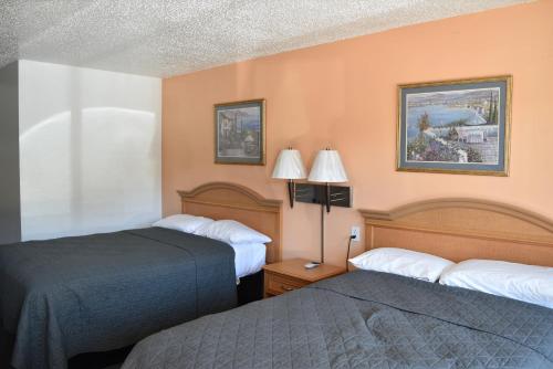a hotel room with two beds and two lamps at Arlington inn in Arlington