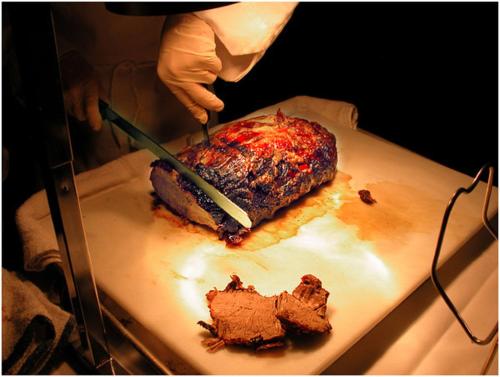 a person cutting a piece of meat with a knife at Kabira Country Club in Kampala