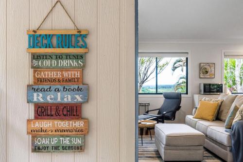 a living room with a wooden sign on the door at Serenity Now in Lennox Head