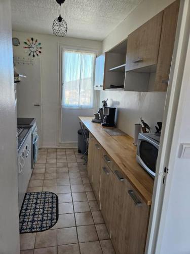 une cuisine avec un comptoir avec un micro-ondes dans l'établissement Superbe appartement avec parking privatif, à Cahors