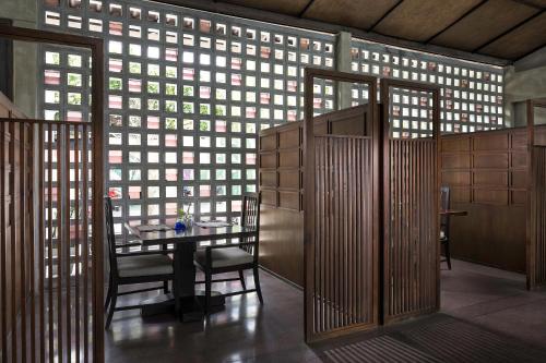 a room with a table and chairs and a wall of windows at Homm Chura Samui in Chaweng
