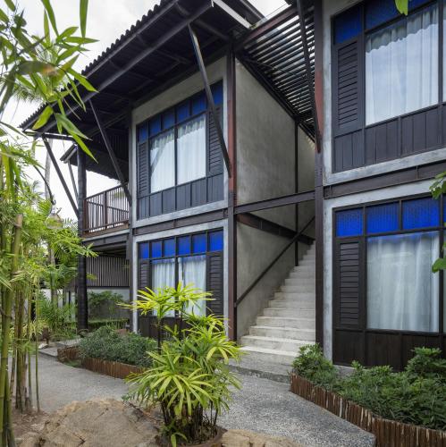 an exterior view of a building with blue windows at Homm Chura Samui in Chaweng