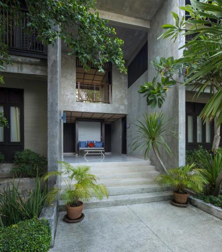 a building with stairs and plants in front of it at Homm Chura Samui in Chaweng