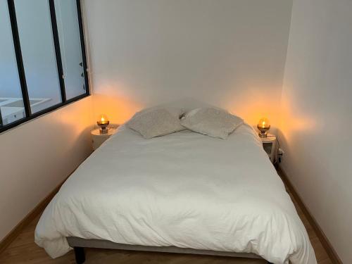 - une chambre avec un lit blanc et 2 lampes dans l'établissement Charmant 2 pièces proche de Cannes, à Mandelieu-la-Napoule
