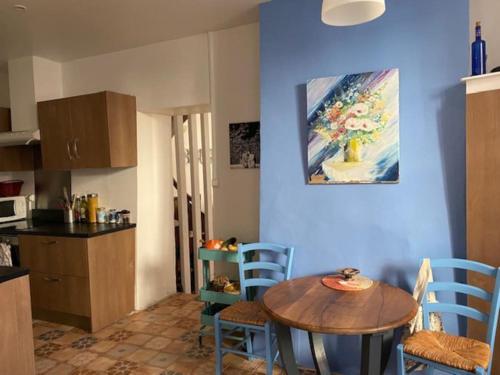 une cuisine avec une table et des chaises dans une pièce dans l'établissement Appartement Le Nid du Saleys - 70 m2 centre ville de Salies-de-Béarn, à Salies-de-Béarn