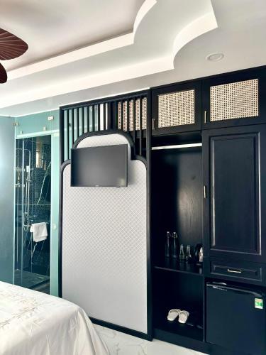 a bedroom with a white refrigerator and black cabinets at Nereus Hotel in Con Dao
