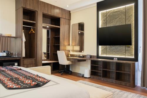 a room with a bed and a desk with a television at BEST WORLD KINDAI HOTEL in Banjarmasin