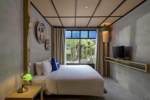a bedroom with a white bed and a window at Homm Chura Samui in Chaweng