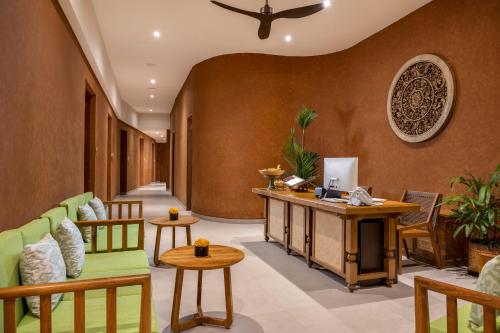 a lobby with a couch and a table and chairs at Adiwana Suweta in Ubud