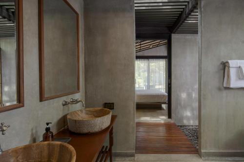 a bathroom with a bowl sink and a bed at Homm Chura Samui in Chaweng