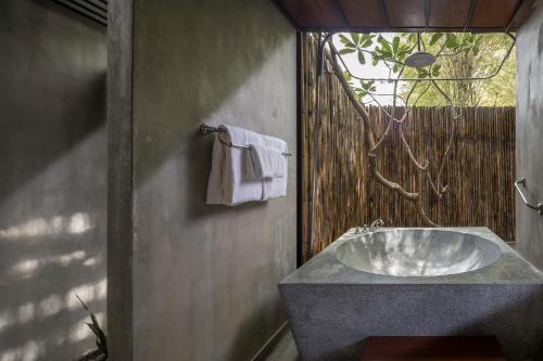 a bathroom with a sink and a towel at Homm Chura Samui in Chaweng
