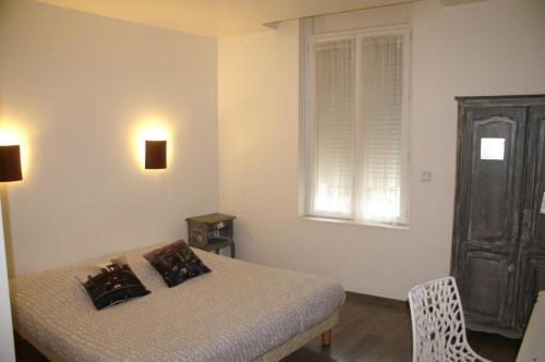 a bedroom with a bed and a window and a chair at Hotel Le 5 in Martigues