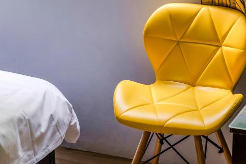 a yellow chair sitting next to a bed at 5-1 Homestay in Kenting