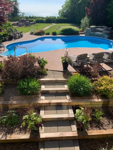 a garden with a wooden path leading to a swimming pool at Drift in Goderich