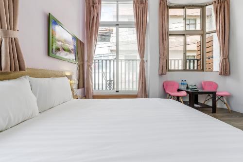 a bedroom with a large white bed and windows at 5-1 Homestay in Kenting