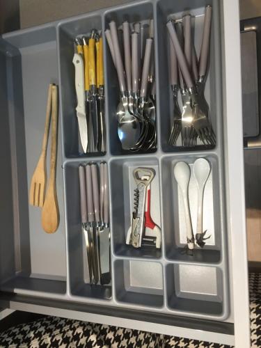 un récipient en plastique rempli d'ustensiles dans un tiroir dans l'établissement studio 24 m² proche arrêt de bus, à Beauvais