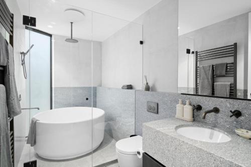 a white bathroom with a sink and a mirror at Luxury KH Chalet in Mount Hotham